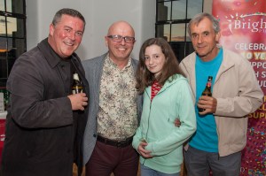 Guests smiling with a drink at the Bright Red Party