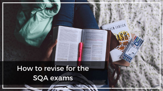 Girl sitting on the bed with an open book and revision tools
